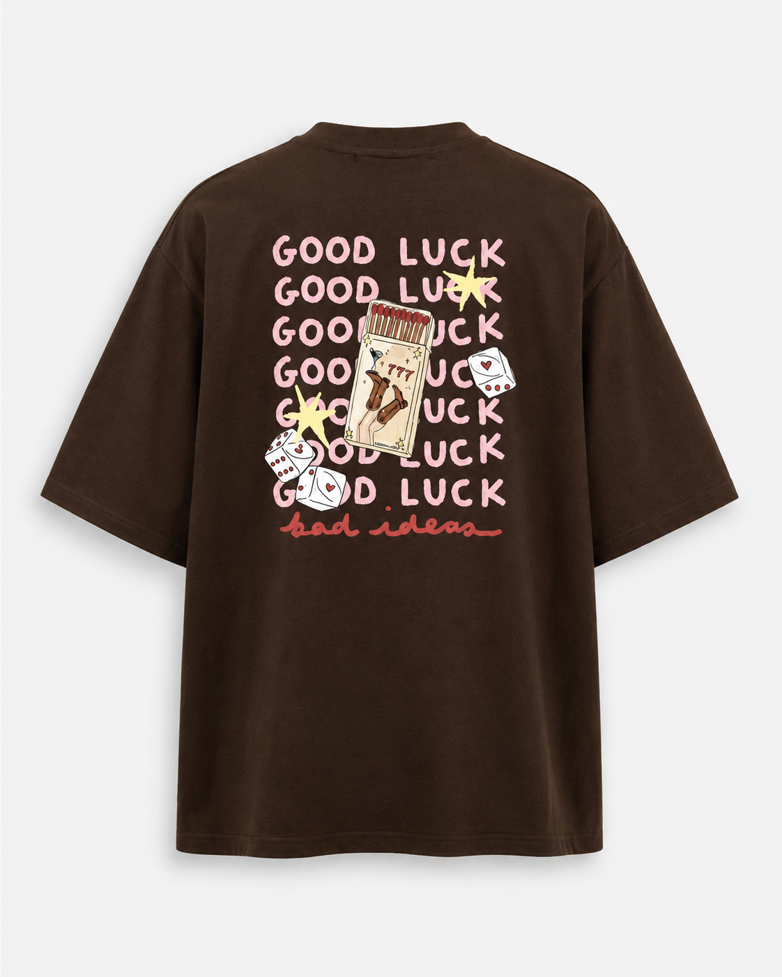 A dark brown oversized short-sleeve t-shirt shown from the back, featuring a graphic print with the word 'GOOD LUCK' repeated in pink, a playing card, dice, and stars.