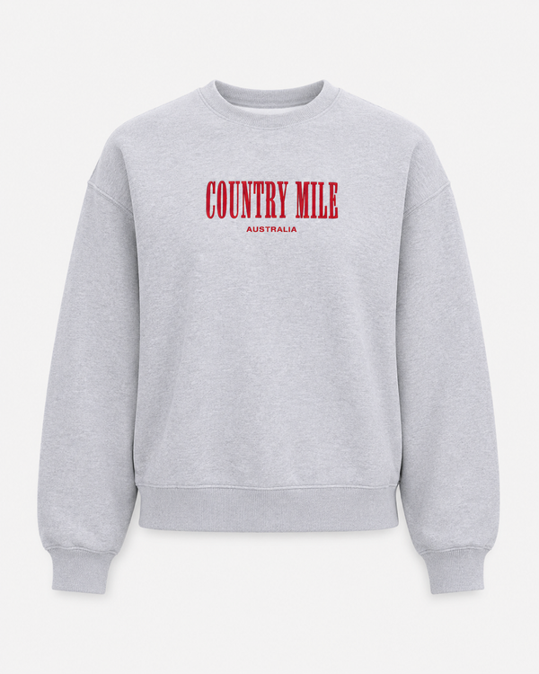 A light gray heather crewneck sweatshirt with 'COUNTRY MILE' printed in red across the chest and 'AUSTRALIA' in smaller red text below, shown against a light gray background.