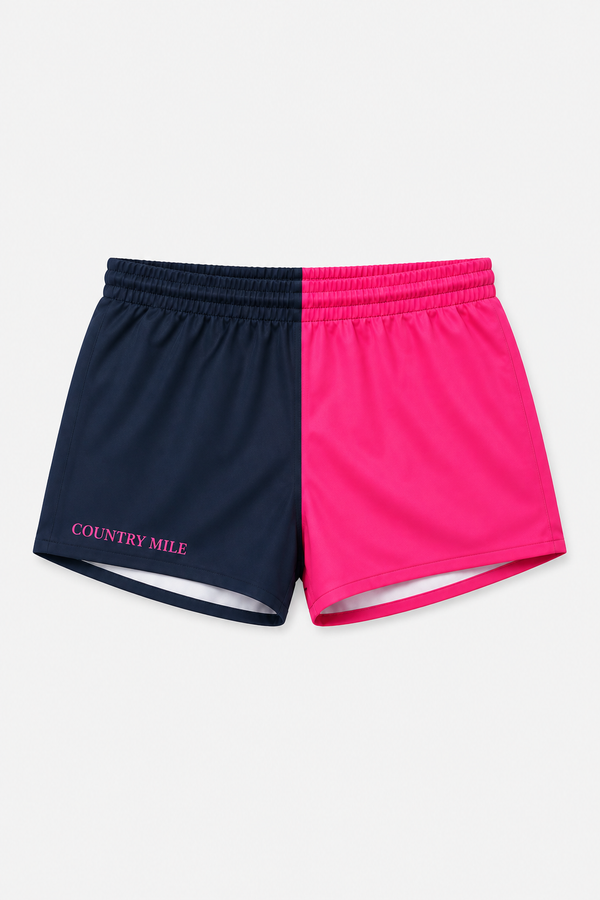 A pair of athletic shorts split vertically into two colors: navy blue on the left and bright pink on the right. The left leg features the text 'COUNTRY MILE' in pink.