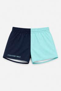 A pair of athletic shorts split vertically into two colors: navy blue on the left with 'COUNTRY MILE' printed in white, and light aqua/mint blue on the right, shown flat on a light gray background.