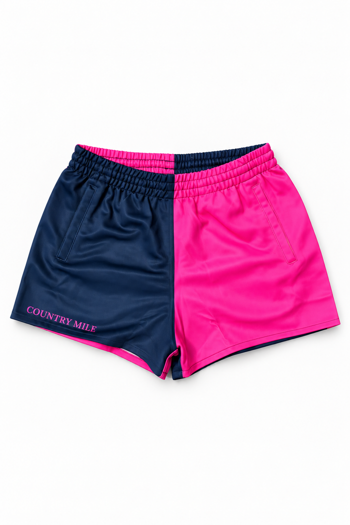 A pair of athletic shorts with a split color design, featuring navy blue on the left side and bright pink on the right side. The waistband is elastic and dark navy.